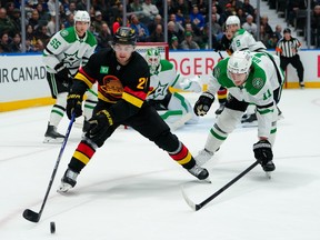 Nathan Bastian #11 of the Dallas Stars defends against Nils Hoglander #21 of the Vancouver Canucks during the first period at Rogers Arena on March 2, 2026 in Vancouver, British Columbia, Canada.