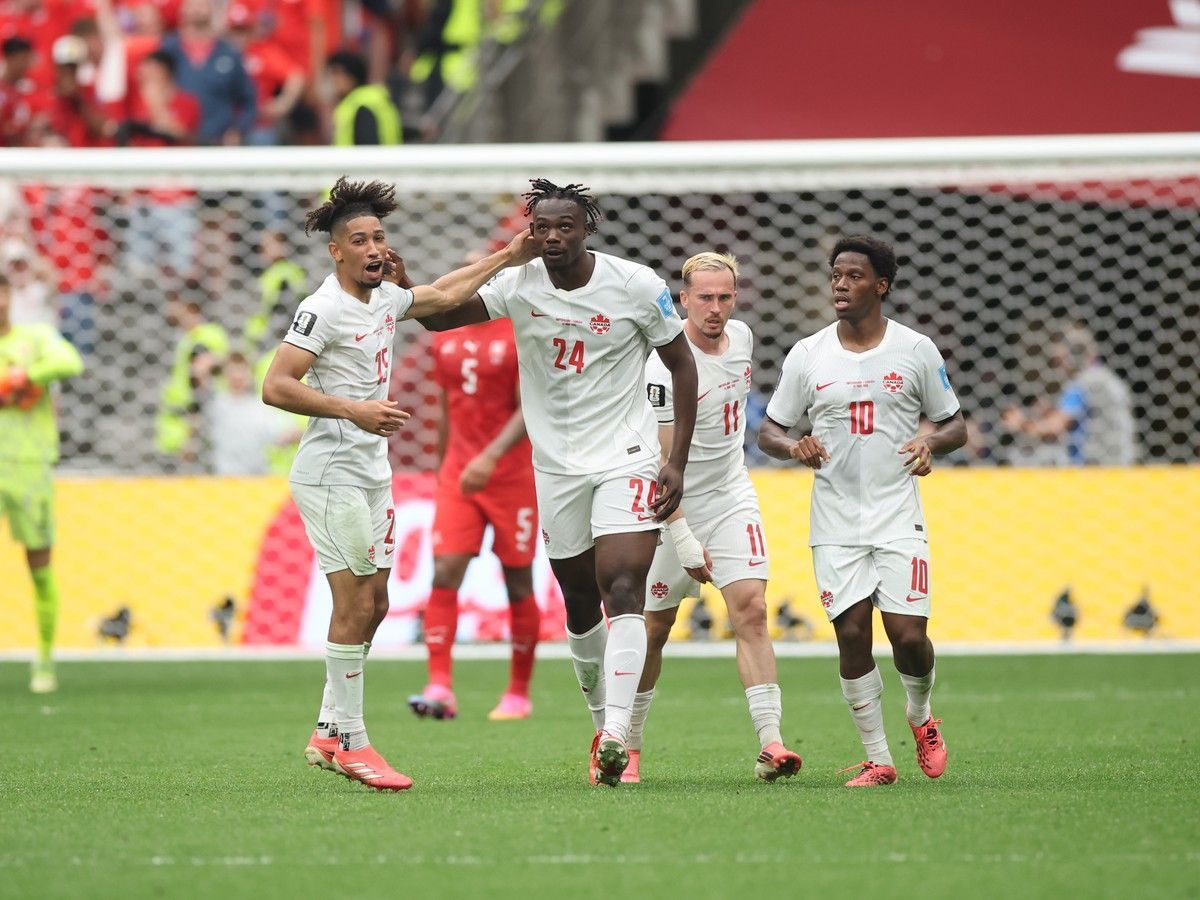 Promise David of Canada celebrates with teammate Nathan Saliba after scoring his team's goal during the World Cup Group B match between Switzerland and Canada at B.C. Place on June 24.