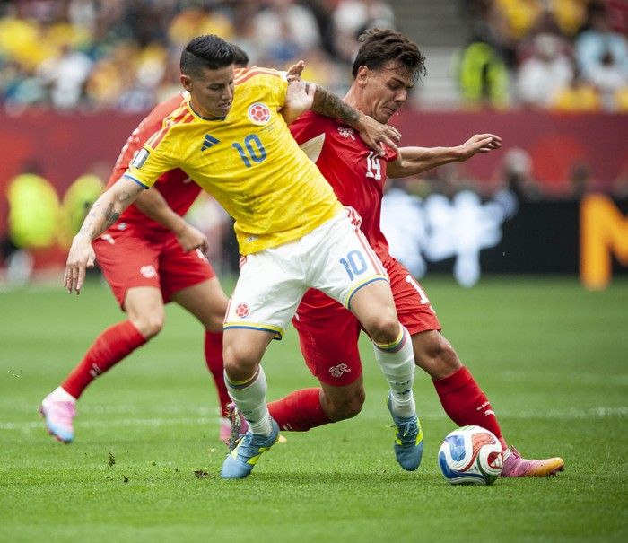Colombia's James Rodriguez fights for the ball with Switzerland's Ardon Jashari in the first half of play