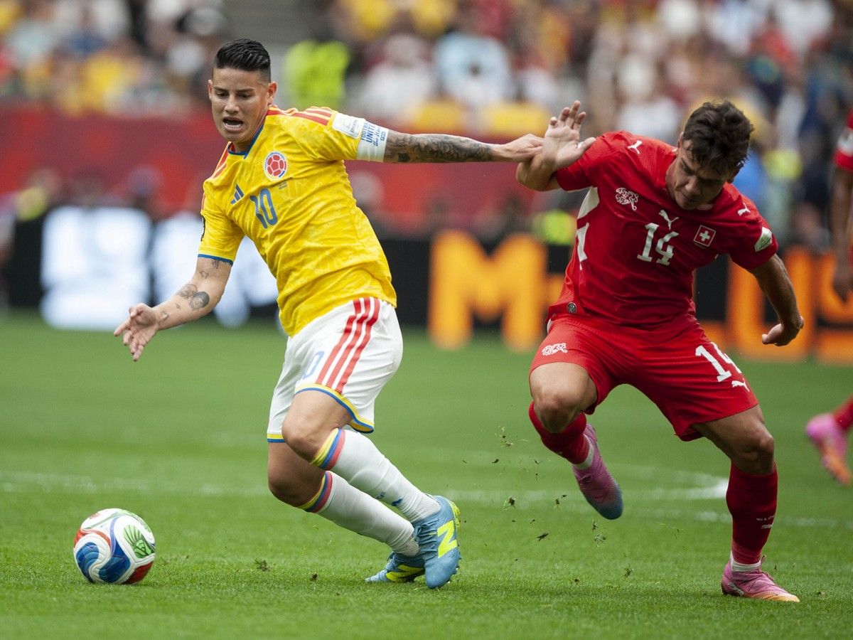 Colombia's James Rodriguez fights for the ball with Switzerland's Ardon Jashari in the first half of play