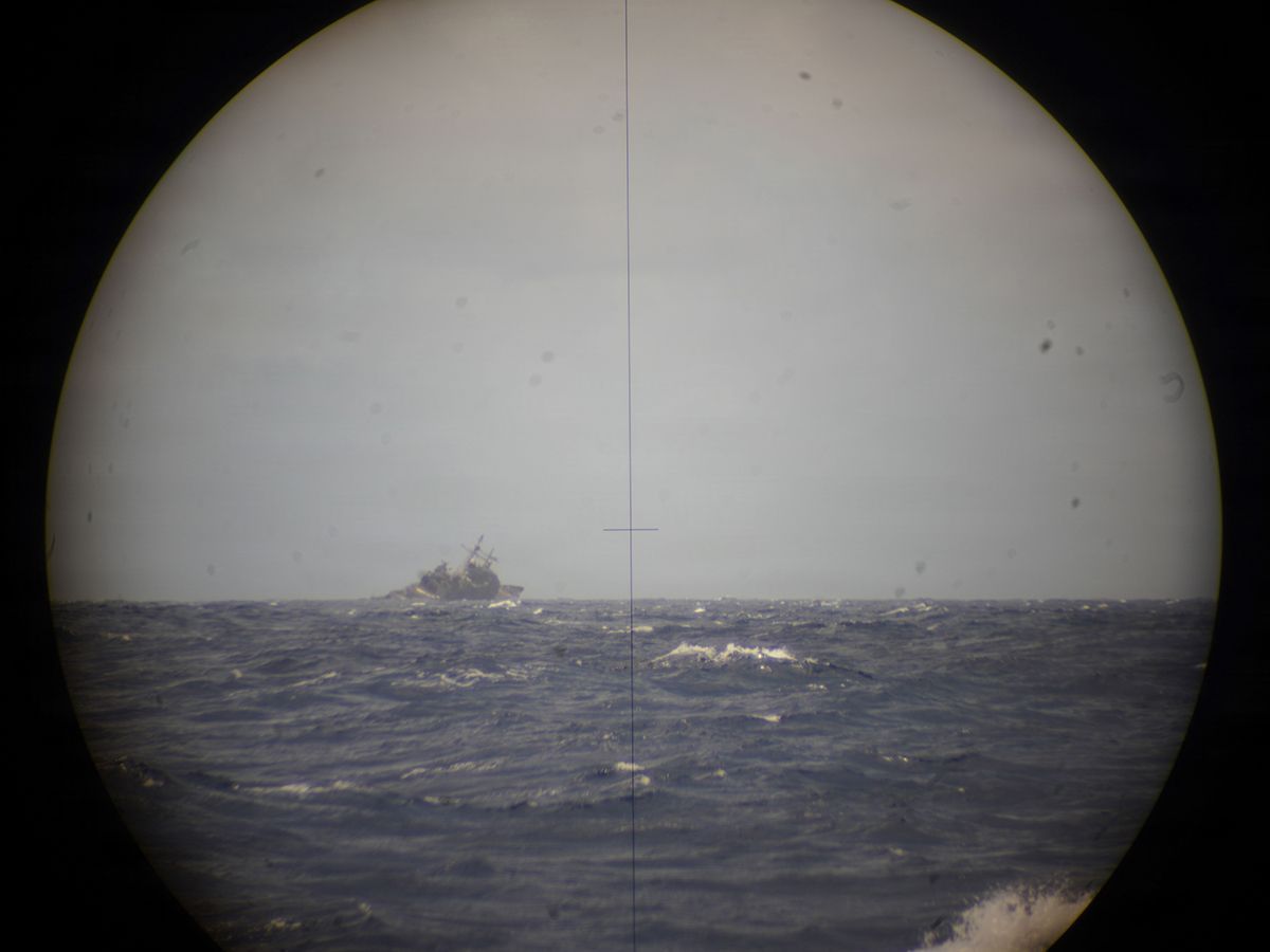 The decommissioned Ticonderoga-class guided-missile cruiser USS Mobile Bay, viewed through the periscope of Royal Canadian Navy Victoria-class long-range patrol submarine HMCS Corner Brook, sinks into the Pacific Ocean after being torpedoed during Exercise Rim of the Pacific 2026, July 12, 2026.