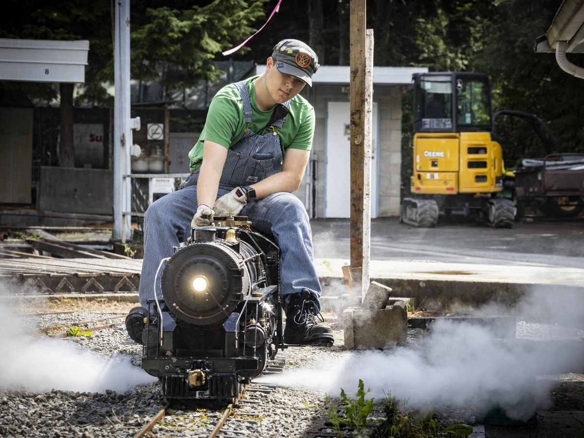 Volunteer engineer Jayden with a steam locomotive.