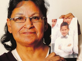 Angelique Masuskapeo holds a photo of her brother, Bobby Bird, who went missing from a residential school in 1969.