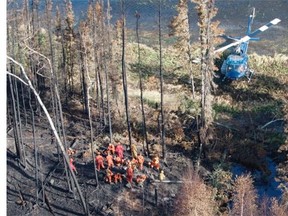 An aerial view of a helicopter delivering military firefighters to burnt forest near Weyakwin, Saskatchewan, July 15, 2015.