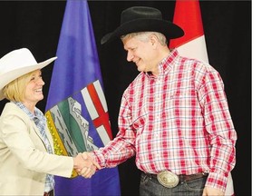 Alberta Premier Rachel Notley, left, greets Prime Minister Stephen Harper with a handshake in Calgary, on Monday.
