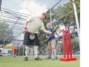 Angus Bell gives batting tips to his son Logan, 6, as his other son Caelan looks on at a cricket batting cage in Montreal on Wednesday. Bell says the name for his business was rejected twice because it sounded too much like a non-profit organization.
