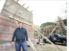 Architect Paul Blaser stands in front of the rammed earth house he is building on Avenue D North. Behind him is a finished wall on the project.