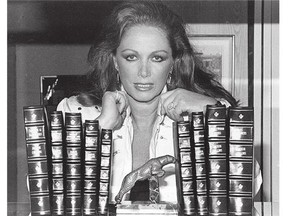 Author Jackie Collins poses with her books in 1984.