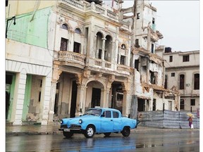 A battered vintage Studebaker trundles past a building in need of repair, on the Malecon in Old Havana, Cuba. Many of the structures in Old Havana are terribly run down but others have been beautifully restored.