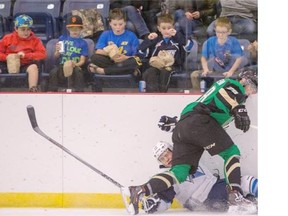 Young fans react as Saskatoon Blades Wyatt Sloboshan is hit into the boards by Prince Albert Raiders Luke Coleman in preseason WHL action on Saturday in Warman.