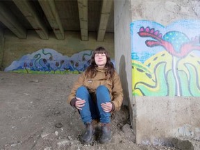 Laura Hosaluk, poses for a photograph with her artwork “Community Garden" a wheat paste mural created in collaboration with Nutana residents, the Nutana Community Association, and the Broadway Business Improvement, under the Broadway bridge on Saturday, September 5th, 2015.