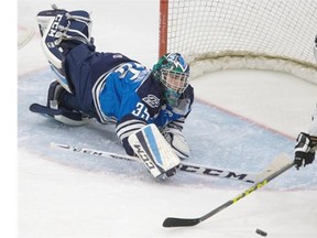 Blades goalie No. 35 Nik Amundrud is able to get his paddle out to block a rolling puck swung at by a Kooteney Ice player next to the crease is first period in WHL action in Saskatoon, Oct. 7, 2015.