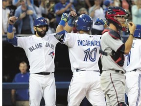 Blue Jays' Edwin Encarnacion, second from left, is congratulated by Jose Bautista, left. after hitting a three-run home run in the fourth inning.
