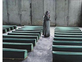 A Bosnian woman mourns by a coffin of her relative in Srebrenica, where 136 bodies found in mass grave sites in eastern Bosnia will be reburied on the 20th anniversary of the Srebrenica massacre that a United Nations court calls a genocide.