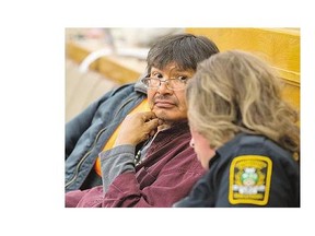 Brandon Nataway, seated in city council chambers with a street patrol officer Monday, prepares to speak about the good effect the officers have had on his life.