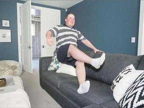 Brody Koshman, 24, gets settled on a couch in the basement of his new, $1.1-million home on Thursday. Koshman is the winner of the Kinsmen Home Lotto. The lottery has raised more than $10 million for charities since its inception.