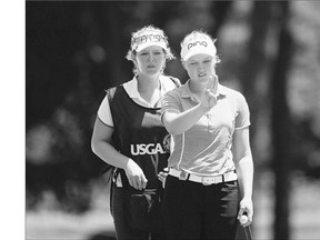 Brooke Henderson of Smiths Falls, Ont. lines up a putt with the help of her sister-caddy Brittany on the 16th green during the second round at the U.S. Women's Open in Lancaster, Pa. Henderson shot 73 to sit at 3-over 143, 10 strokes in arrears of the lead.