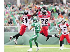 Calgary Stampeders defensive backs Joe Burnett, left, and Brandon Smith are about to collide while breaking up a pass intended for the Saskatchewan Roughriders Weston Dressler on Saturday in Regina. The Riders lost a close 34-31 game Saturday to the Stamps to fall to 0-8 on the season.