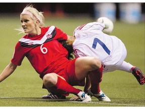 Canada's Kaylyn Kyle, left, ties up Cuba's Marianela Morales Chacon during a game in 2012. Like many of her teammates, Kyle's love affair with soccer took a beating at the 2011 World Cup when Canada finished dead last.