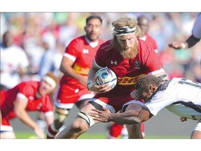 Canadian rugby forward Evan Olmstead shows off the kind of physicality in fighting off a defender that figures to stand him in good stead at the Rugby World Cup in the U.K.