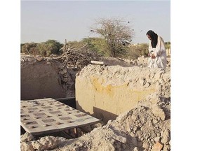 A caretaker at Timbuktu's mausoleums prays at a damaged tomb in 2014. The reconstruction of the mausoleums took more than a year and cost about $500,000.