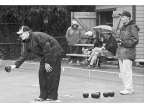 Carter Watson, left, of Regina playing against Nathan Jacobucci of Team Manitoba finishes the Lawn Bowling final round robin games in the rain Thursday.