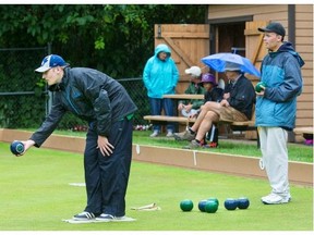 (L) Carter Watson of Regina playing against Nathan Jacobucci of Team Manitoba finish the Lawn Bowling final round robin games in the rain at the Nutana Club, on August 6, 2015.