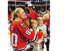 Chicago forward Patrick Kane celebrates the team's cup win Monday night with the family of former Blackhawks equipment manager Clint Reif, who died at home in December.