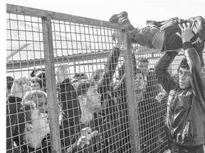 A child is passed over a fence as migrants and refugees prepare to board a train heading to Serbia from the Macedonian-Greek border near Gevgelija. European Union and Balkan leaders held emergency talks on Europe's refugee crisis amid threats from three front line states to close their borders if northern EU countries stop accepting migrants.