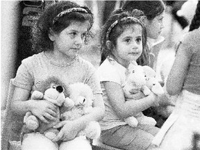 Children hold donated toys at a refugee facility in Berlin last Thursday. The influx of refugees has led to an increasing polarization in Germany.