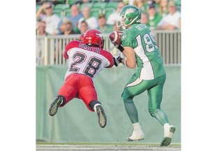 Chris Getzlaf catches a touchdown pass in front of Calgary's Brandon Smith during pre-season CFL action.