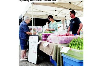 Chris and Juanita Dunlop serve a customer at their booth at the Community Farmers' Market of Saskatoon.