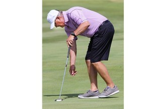 Colin Coben reaches for his ball after making an 18-inch putt for birdie on number 3 Heather at Moon Lake during the Saskatoon Auto Clearing senior men’s golf championship on Thursday. (RICHARD MARJAN /The StarPhoenix)
