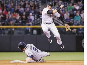 Colorado Rockies shortstop Troy Tulowitzki throws to first to complete a double-play against the San Diego Padres earlier this season. Tulowitzki will now be making plays for the Toronto Blue Jays after Monday's deal, which brings the infielder and LaTroy Hawkins to Toronto for Jose Reyes and three minor-league pitching prospects.