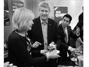 Conservative Leader Stephen Harper and wife, Laureen, serve Halo Halo, a dessert with origins in the Philippines, with local candidate Francisco "Jojo" Quimpo, right, to local members of the Filipino community while campaigning in Vancouver on Monday.