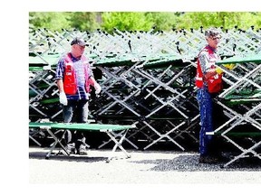 Red Cross volunteers prepare cots for removal at the Henk Ruys Soccer Centre on Monday while the last handful of evacuees prepare to leave for home.