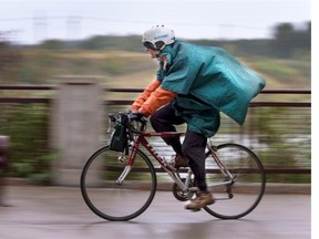 A cyclist is well prepared for a cool rainy day.