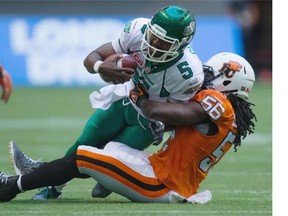 Saskatchewan Roughriders’ quarterback Kevin Glenn is tackled by B.C. Lions’ Solomon Elimimian during the first half of a CFL football game in Vancouver, B.C., on Friday.