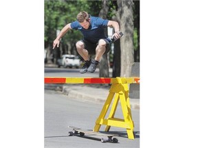 David Kline didn't find the traffic barricades on Spadina Crescent an obstacle to his long board jumping style on Monday,