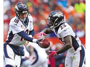 Denver Broncos running back Ronnie Hillman, right, takes the handoff from Peyton Manning against the Browns Sunday in Cleveland.