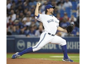 R.A. Dickey of the Toronto Blue Jays delivers a pitch in his team's 5-3 win over the Tampa Bay Rays Friday. It was his 100th career win.