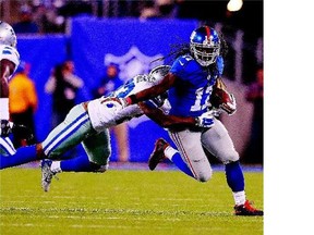 Dwayne Harris of the New York Giants breaks a tackle by Corey White of the Dallas Cowboys en route to scoring the game-winning touchdown on a fourth-quarter kickoff return for 100 yards against the Dallas Cowboys in NFL action Sunday in East Rutherford, N.J. The Giants won, 27-20.