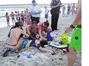 Emergency responders assist a teenage girl who was injured after a shark attack in Oak Island, N.C., last month.