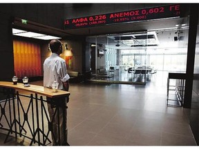 An employee of the Athens Stock Exchange follows the bad news Monday as stocks plunged 22 per cent on opening.