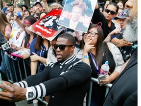 Kevin Hart poses with fans after arriving for the world premiere of “Get Hard” during the South by Southwest Film Festival on March 16, 2015, in Austin, Texas.