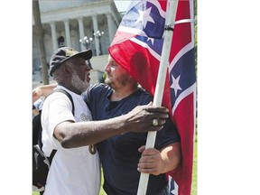 Ernest Branch, left, hugs a man Tuesday carrying a Confederate flag. Branch said he respects the man's right to carry the flag, but says he is against flying it on the Capitol grounds in Columbia, S.C.