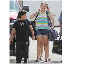 Evacuees leave the Henk Ruys Soccer Centre Thursday.