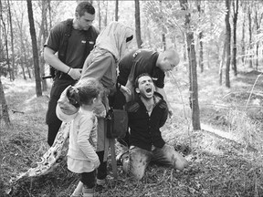 The father of a migrant family is arrested near the village of Roszke on the Hungarian-Serbian border on Friday. Hungarian police have intercepted approximately 141,500 people this year crossing into Hungary, mostly from neighbouring Serbia.