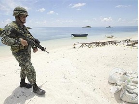 A Filipino soldier patrols a beach in Pagasa Island (Thitu Island) at the contested Spratly Islands in the South China Sea in this May file photo.