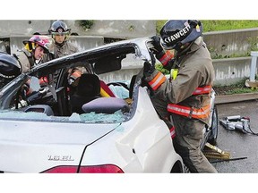 Fire fighters demonstrate the dismantling of a vehicle to gain access to passengers Monday in Saskatoon.